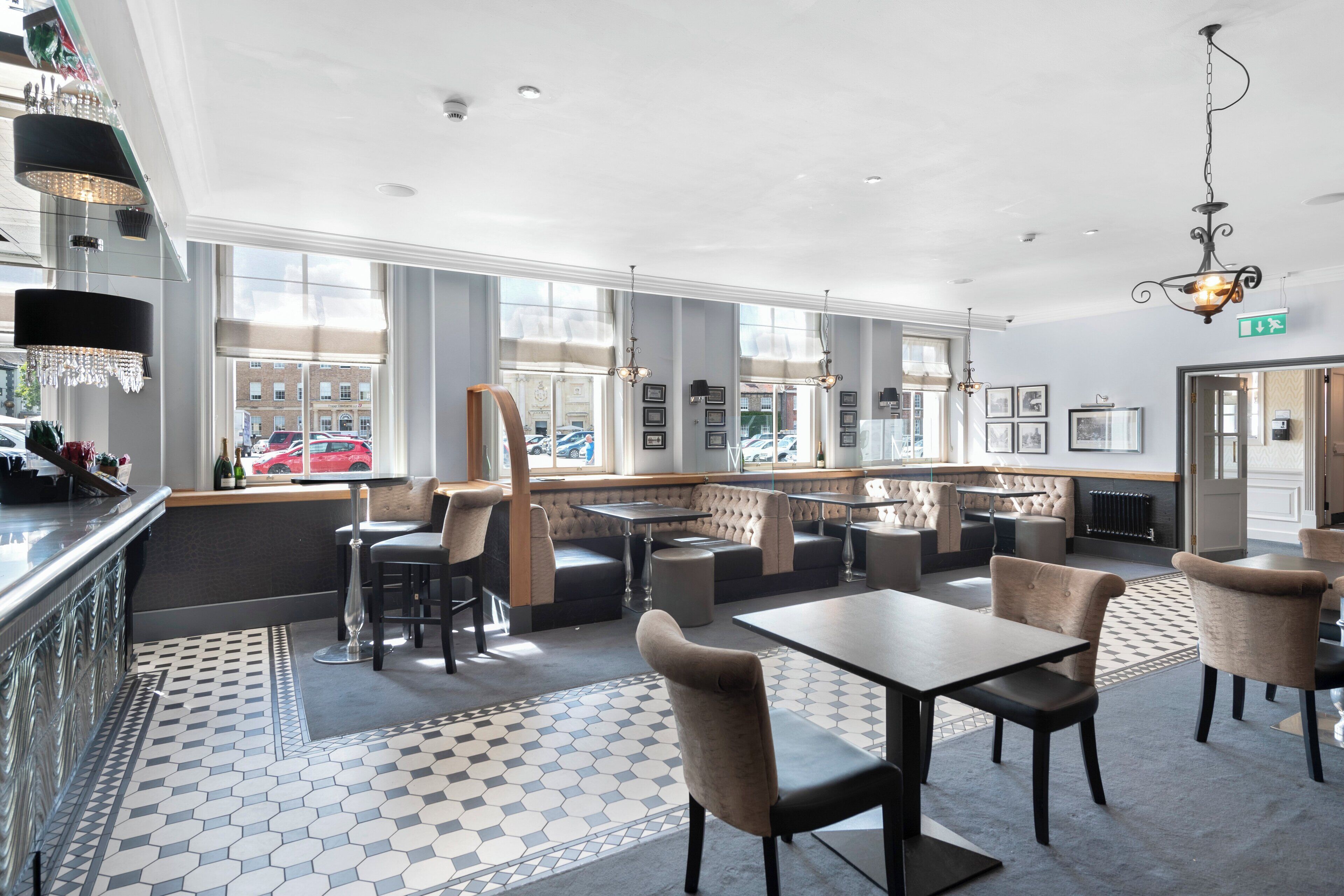 A modern restaurant with high ceilings, large windows, and a mix of seating options including booths and tables.