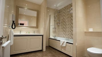 A modern bathroom with a large mirror, a glass shower enclosure, and a toilet.