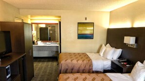 A hotel room with two beds, a television, a desk, and a bathroom visible through an open door. - Quality Inn Riverside near UCR and Downtown (Riverside)