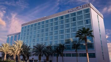 Un moderno edificio de hotel con señalización destacada de 'Swissotel'.
