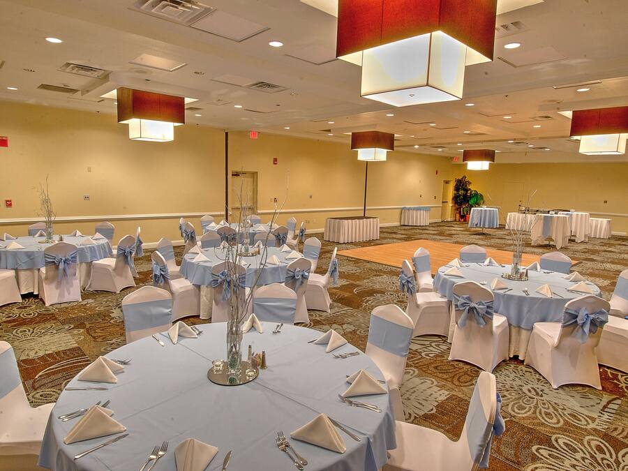 Une salle de conférence équipée de tables rondes, de chaises et d’un élément décoratif central.