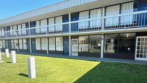 Un edifici modern amb teulada plana, finestres grans i una zona enjardinada ben cuidada.