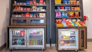 A vending machine stocked with various snacks and beverages, including chips, sodas, and energy drinks. - Hampton Inn Commerce (Commerce)