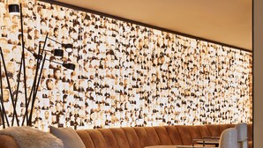 Un espace de détente moderne comprenant un canapé, des fauteuils et un mur recouvert de photographies.