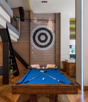 A pool table with two chairs, a target wall, and a staircase. - Hotel Zetta San Francisco (San Francisco)