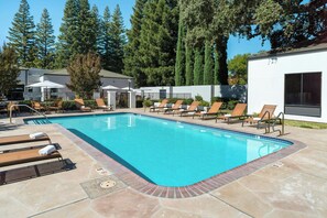 Une piscine avec des chaises longues et un poste de surveillance pour les sauveteurs.