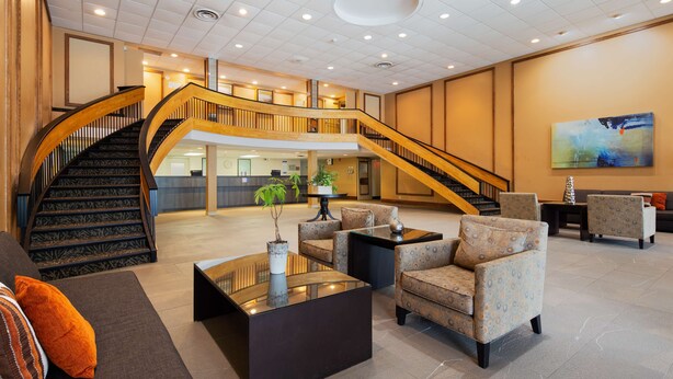 Un vestíbulo amplio con una imponente escalera, asientos cómodos y una zona de recepción.
