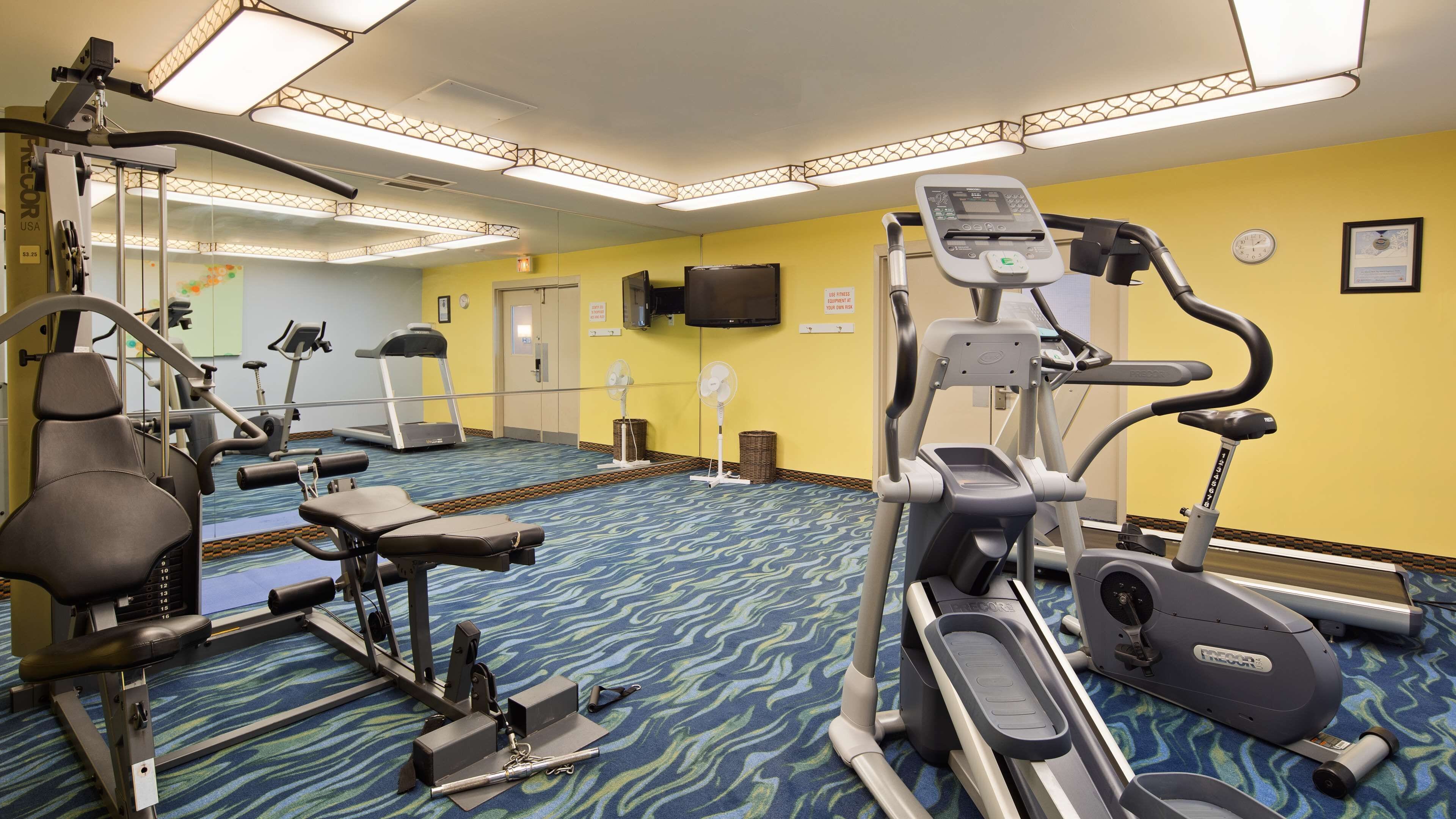 A fitness center with treadmills, elliptical machines, and weight machines.