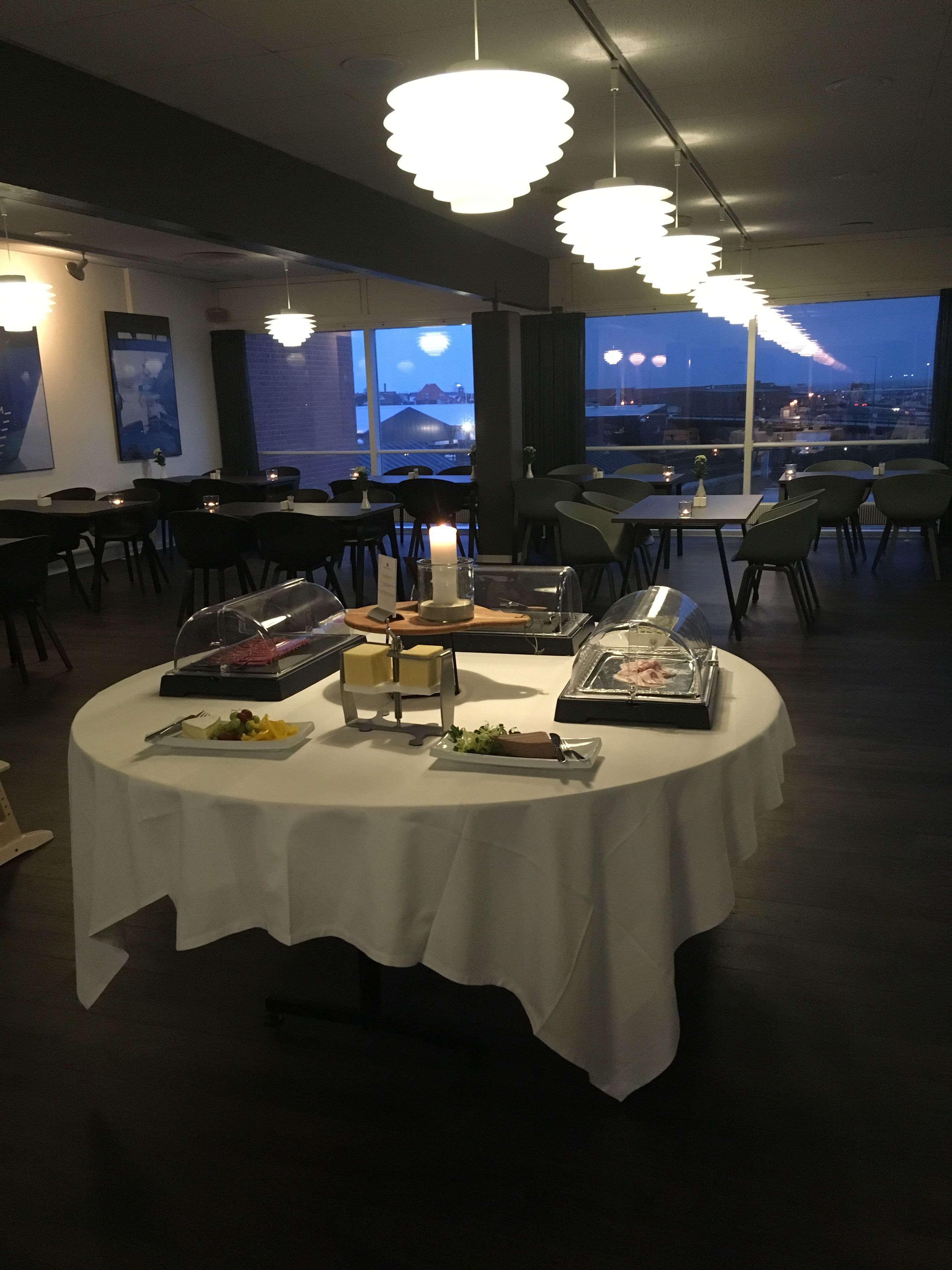 Spisested med runde borde, stearinlys og en buffet.