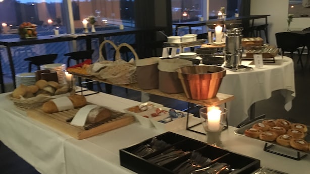 Una mesa de buffet con diferentes alimentos, una olla de cobre y una vela.