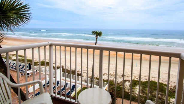 Ein Balkon mit Blick auf Strand und Meer.