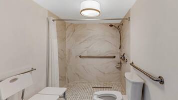 A modern bathroom with a shower, toilet, and grab bars.