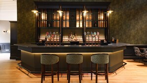 A bar area with a counter, multiple taps, and three bar stools. - Donnington Hotel, Spa & Golf (Newbury)