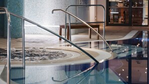 A swimming pool with a glass barrier and metal handrails. - Donnington Hotel, Spa & Golf (Newbury)
