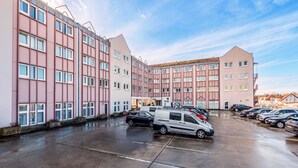 A multi-story parking garage with a row of parked cars and a van. - B&B HOTEL Rastatt (Rastatt)