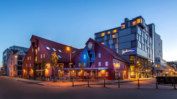A modern building with a red facade and a sign that reads "Radisson."