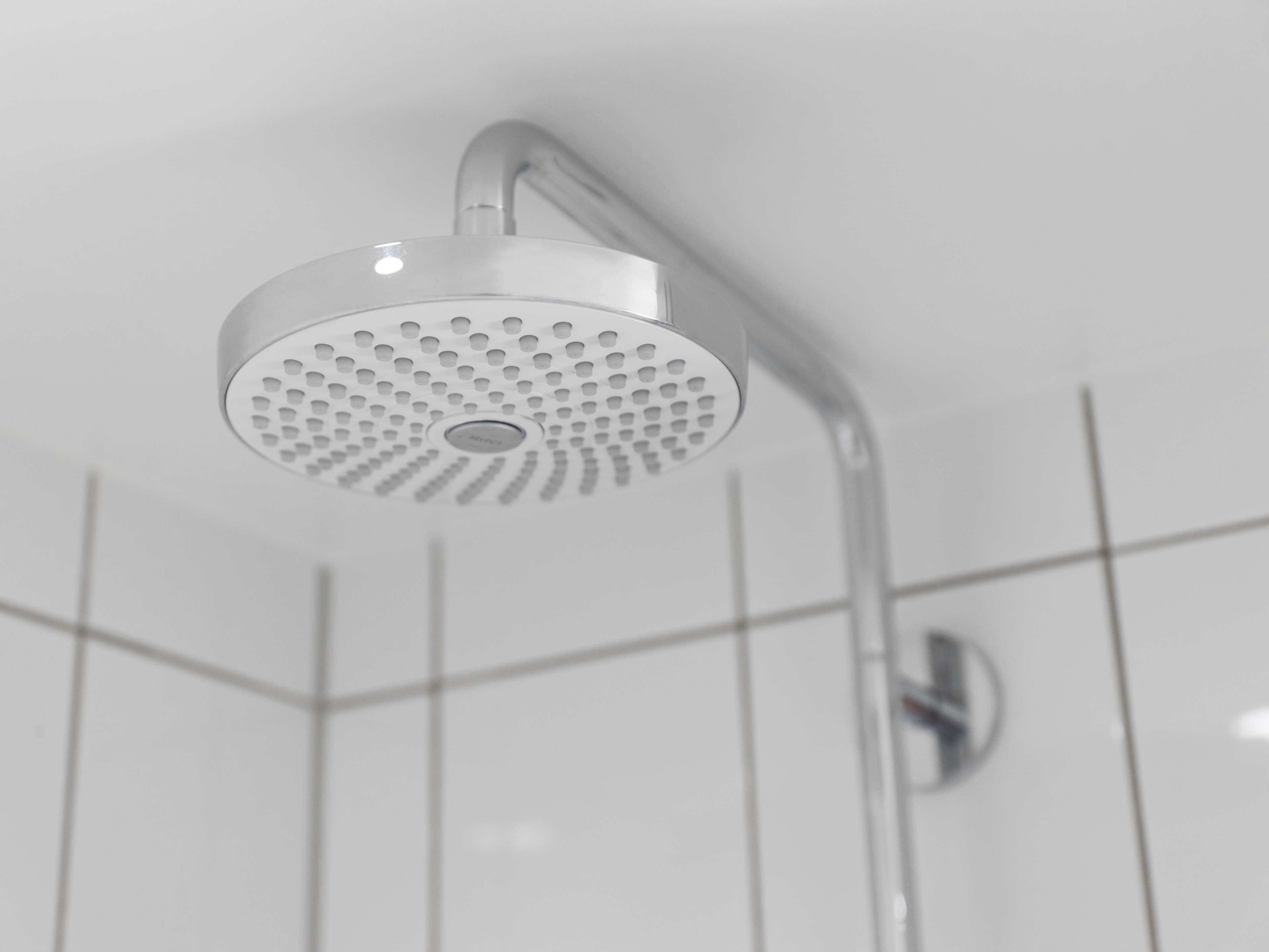 A modern showerhead with a circular design and multiple holes.