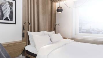 Een moderne hotelkamer met een bed, een bureau en een raam met uitzicht op de stad.