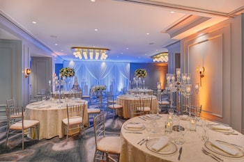 Banquet hall with round tables set for dining, fine china, and elegant centerpieces, amidst classic architectural design and tasteful artwork. at Le Meridien Washington, D.C., The Madison