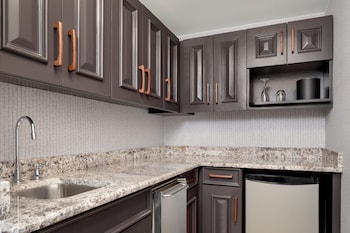 Kitchen features sleek cabinetry, granite countertop, and a stainless steel sink and dishwasher. at Le Meridien Washington, D.C., The Madison