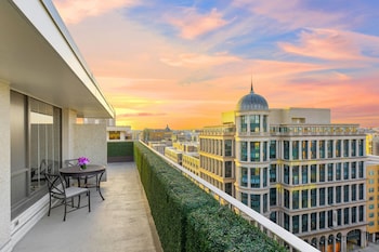 Enjoy the city view from this urban balcony with a glass railing, featuring a small table and two chairs. at Le Meridien Washington, D.C., The Madison