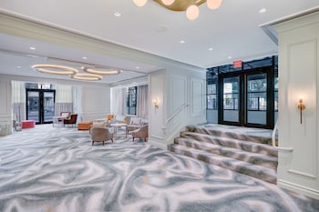 Step into a stylish lobby with a spacious seating area, sofas, and armchairs, plus a staircase leading to an upper level. at Le Meridien Washington, D.C., The Madison