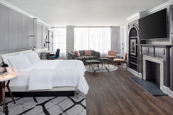 A modern lobby with a sofa, two chairs, a small table, and a reception desk. at Le Meridien Washington, D.C., The Madison