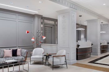 A modern buffet setup with marble countertops, wooden cabinets, and a variety of food items. at Le Meridien Washington, D.C., The Madison