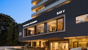 A modern building with a sign reading "BAR V" and "RESTAURANT VESTERBRO". - Comwell Hvide Hus Aalborg, Dolce by Wyndham (Aalborg)