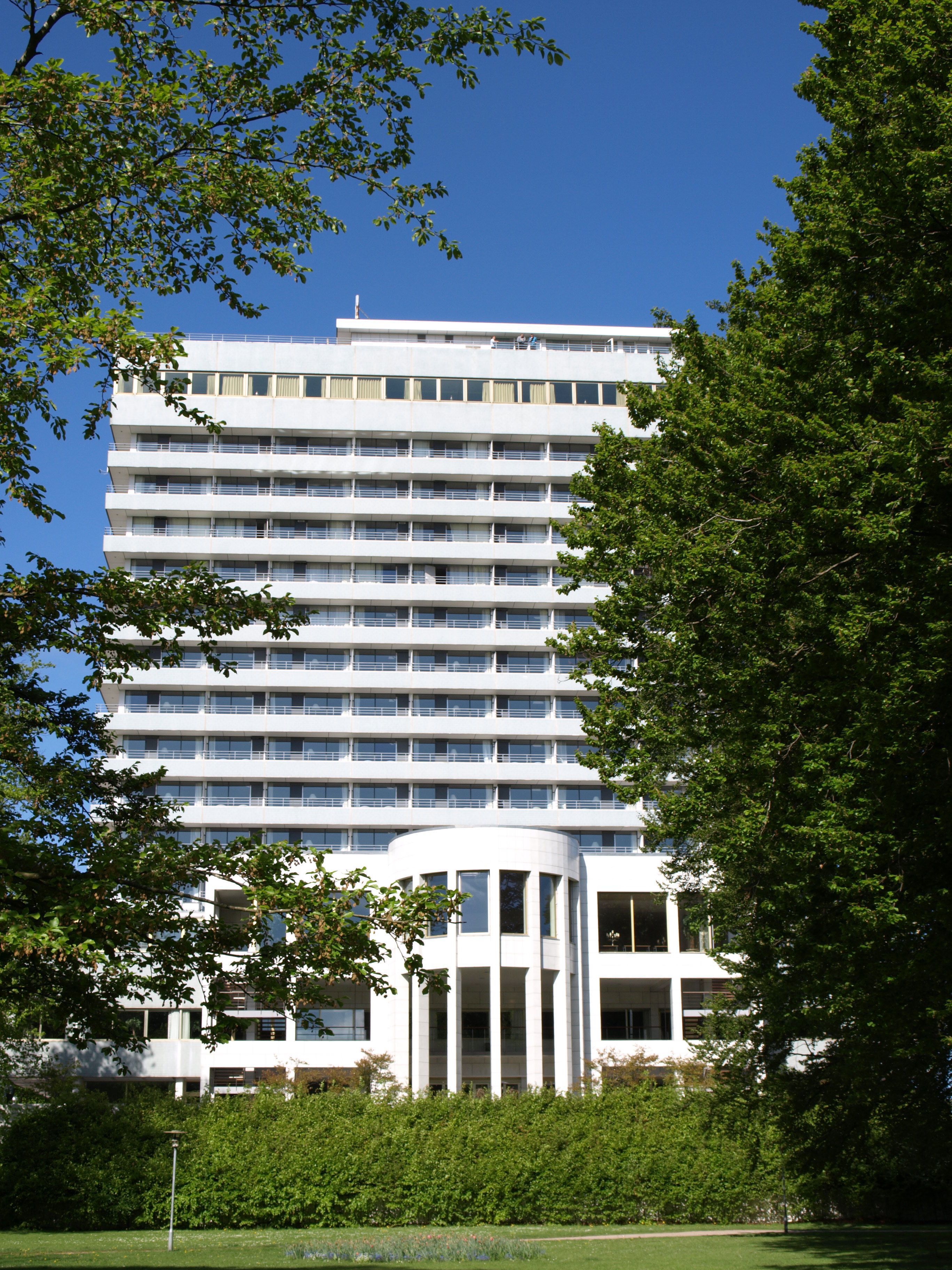 A multi-story hotel with a modern architectural design, featuring a central courtyard and a flat roof.