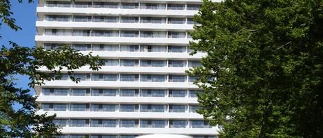 Un hotel de varios pisos con un diseño arquitectónico moderno, que cuenta con un patio central y un techo plano.