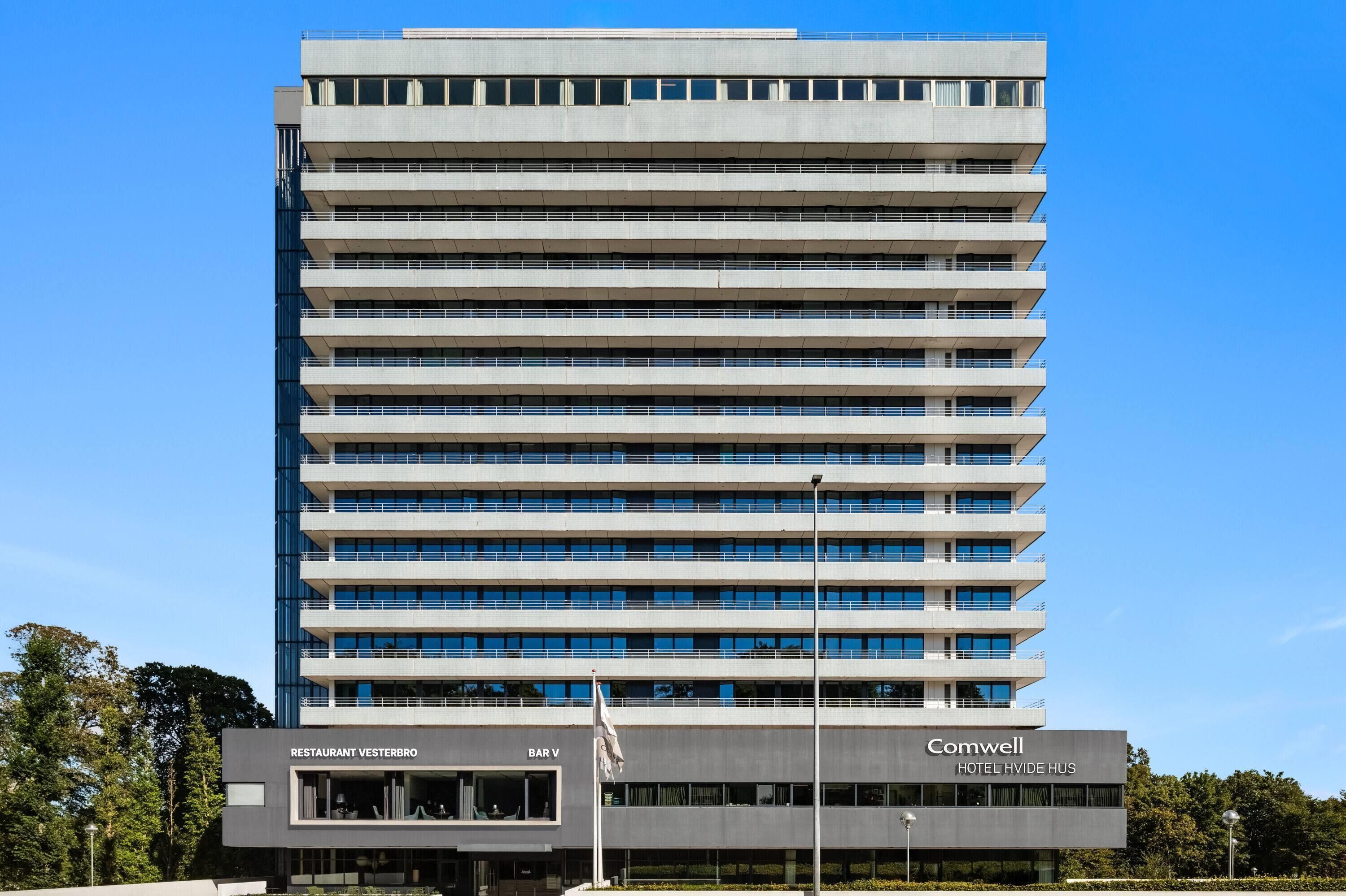 Un hôtel à plusieurs étages doté d’une architecture moderne, caractérisé par un toit plat et une série de balcons.