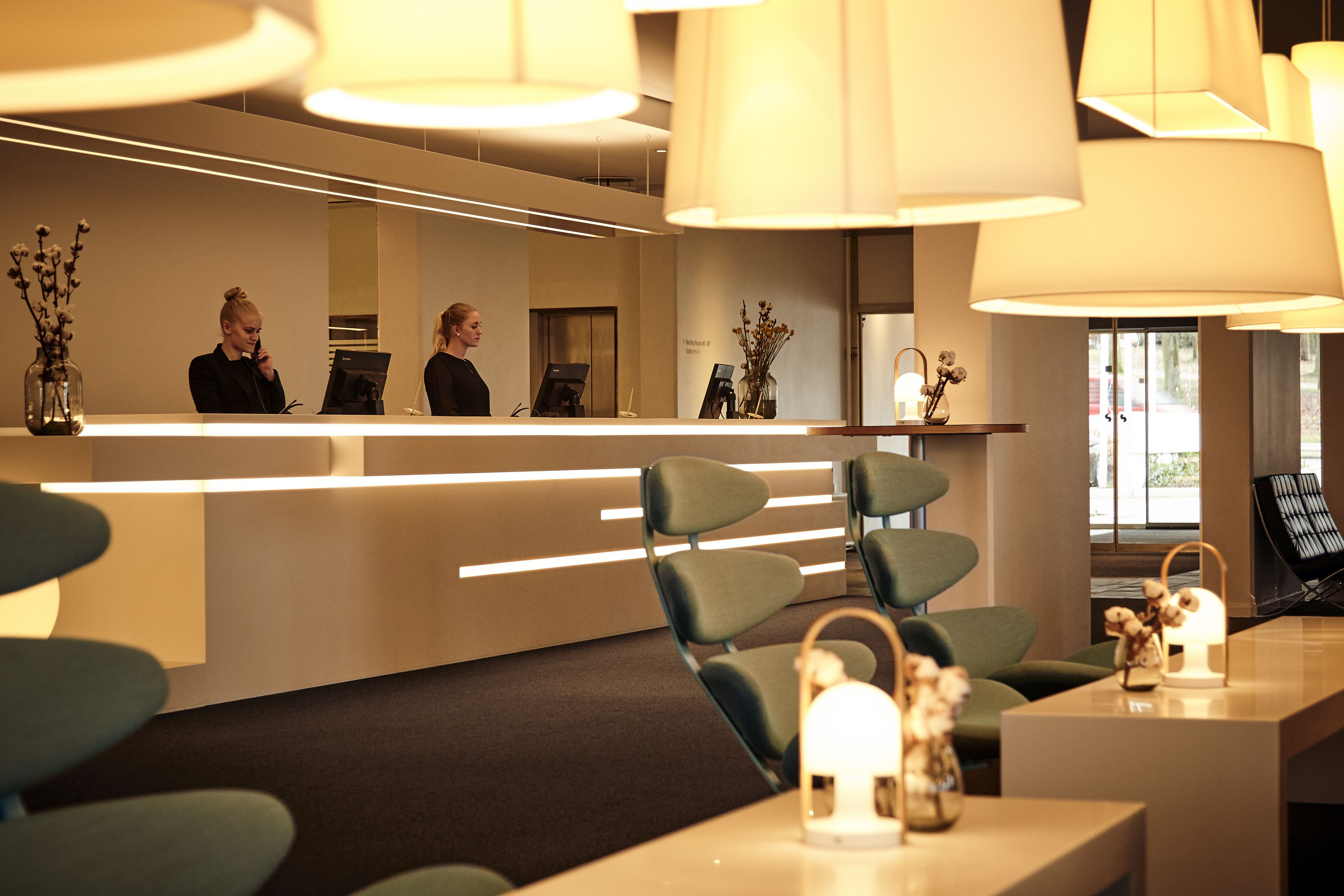 A modern reception area with a counter, seating, and ambient lighting.