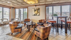 Un espace de détente moderne, doté de différents types de sièges, notamment des canapés et des fauteuils, disposés autour d’une table centrale.