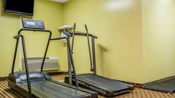 Een fitnessruimte met loopbanden, een hometrainer en een bedieningspaneel.