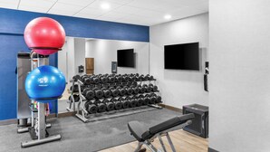 A gym with exercise equipment, including a bench, dumbbells, and exercise balls. - Hampton Inn Knoxville - Airport (Alcoa)
