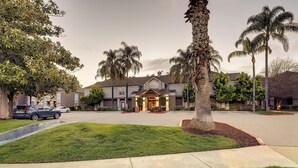 A residential area with a house featuring a front porch and palm trees. - Sonesta ES Suites San Jose Airport (San Jose)