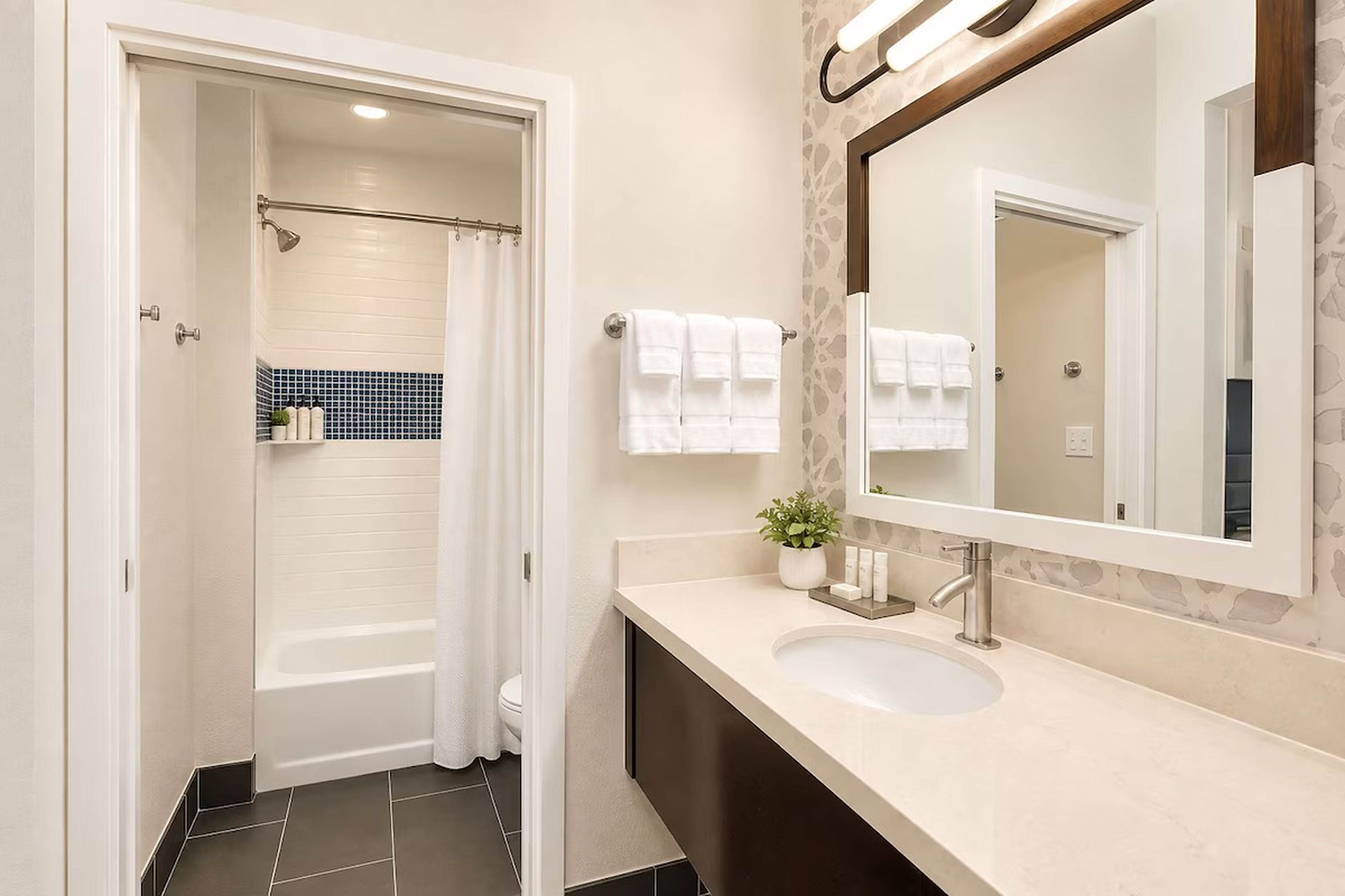 A modern bathroom with a shower, toilet, and sink.