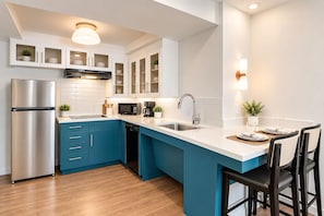 A modern kitchen with a stainless steel refrigerator, a microwave, and a dishwasher.