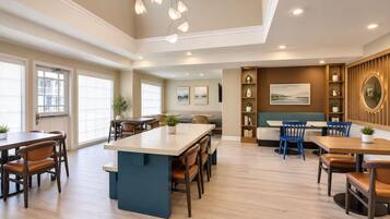 A spacious dining area with a central island, multiple seating arrangements, and a view of the outdoors.