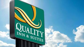 Placa para Quality Inn & Suites com logotipo estilizado e texto.
