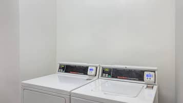 A white commercial washer and dryer unit with digital displays, a card reader, and a visible payment option.
