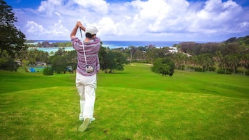 Enjoy a serene golfing experience with ocean views and a lush landscape.