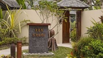 Casa número 325 Shefa, rodeada de exuberante vegetación y un pequeño jardín.