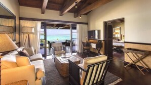 A spacious living area with a view of the sea, furnished with sofas, chairs, and a coffee table. - Warwick Le Lagon - Vanuatu (Port Vila)
