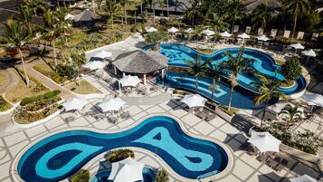 Relax by the infinity pool, surrounded by palm trees and tropical landscaping.