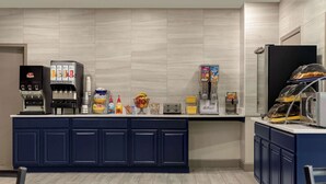 Una cocina moderna con una cafetera integrada, un tostador y diversos alimentos sobre la encimera.