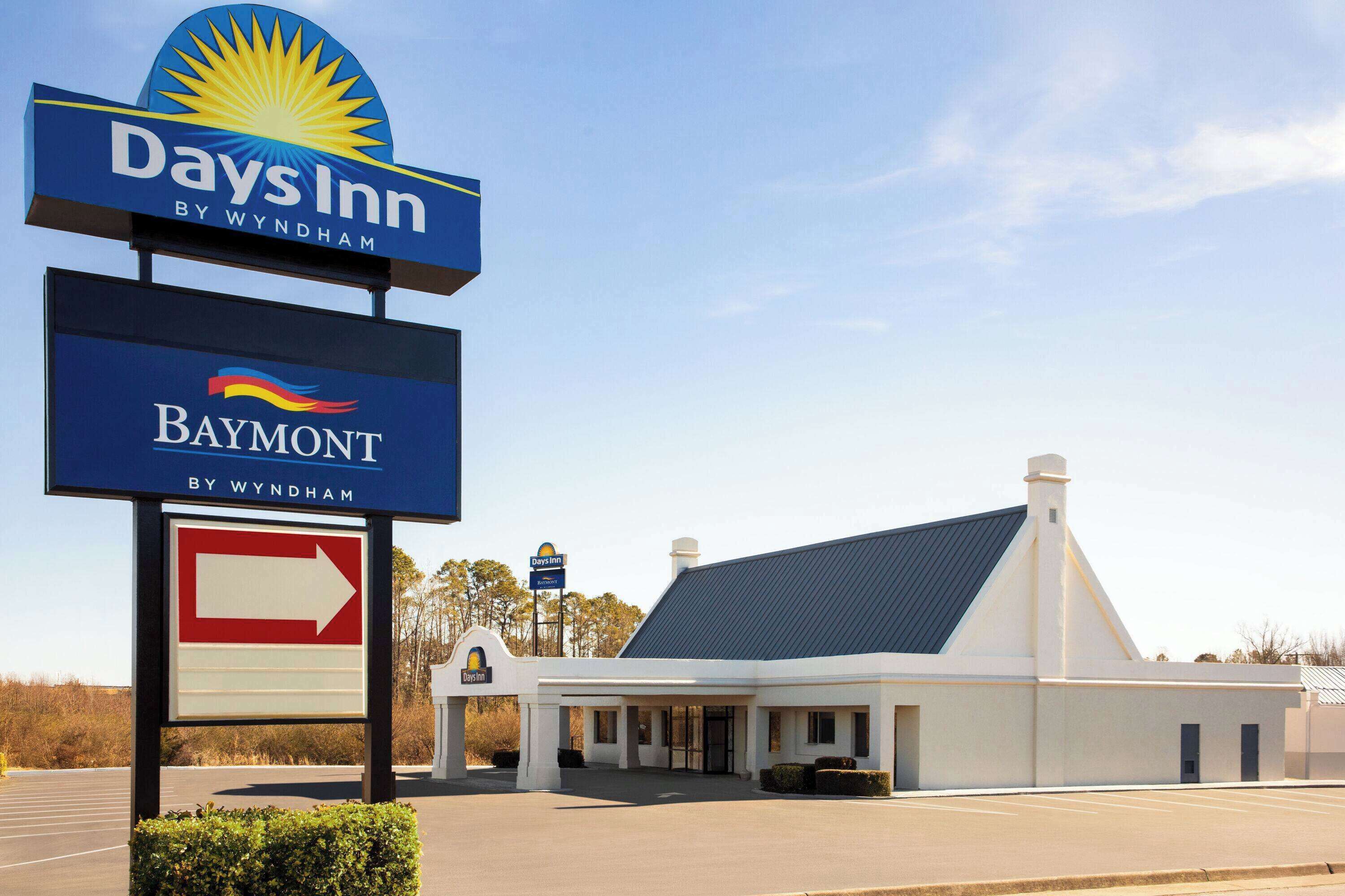 A Days Inn by Wyndham Baymont with a clear directional sign and a parking lot.
