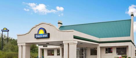 A Days Inn with a green roof and beige exterior walls.