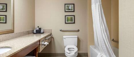 A bathroom with a toilet, sink, and bathtub. There are two framed pictures on the wall.
